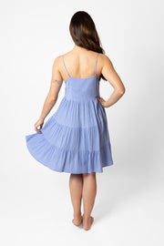 Brunette model facing front, wearing Bahama Blue Miami Tiered Strappy Mini Dress. Features adjustable straps, a flirty tiered empire silhouette, smocked back, and pockets. Crafted from lightweight rayon and lined in white. Perfect for date night or any vacation-ready occasion. Koy Resort affordable vacation, cruise, and resort-wear.