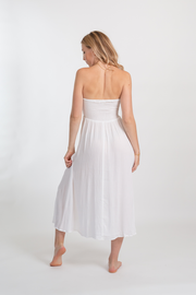 Koy Resort miami convertible smocked hi-lo hem 2-1 skirt/ dress in white. Blonde model wearing White Natural Miami Bandeau Skirt/Dress with a convertible 2-in-1 style. Features figure-flattering smocked fabric, hi-lo skirt, and ruffle sleeve. Lined bodice and skirt, and bra friendly. Versatile and stylish, perfect for various occasions. Koy Resort affordable vacation, cruise, and resort-wear.