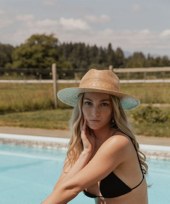 koy resort model wearing zuma beach cover up collection by the poolside in Tuscany, Italy. Wearing Lack of Color straw hat. 