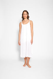 Brunette model facing front, wearing White Miami Side Slit Strappy Midi Dress with a loose and flowy fit, side slits, white lining, and adjustable cord at the back. Made from breezy rayon fabric for an effortless and fashion-forward look. Koy Resort affordable vacation, cruise, and resort-wear.