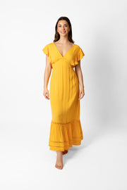 Brunette model facing front, wearing Mango Miami Luxe Ruffle Sleeve Maxi Dress with luxe ruffle sleeves, deep v-neck, semi-exposed back, empire waist, luxury crochet detail, and frill hem. Made from rayon fabric with a lined bodice and skirt. Koy Resort affordable vacation, cruise, and resort-wear.