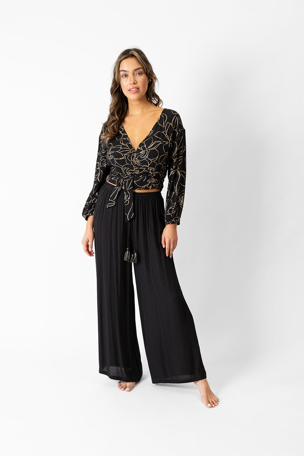 koy resort miami shine golden flower print long sleeve wrap top for spring 2024 women's fashion collection worn with miami  wide leg pants