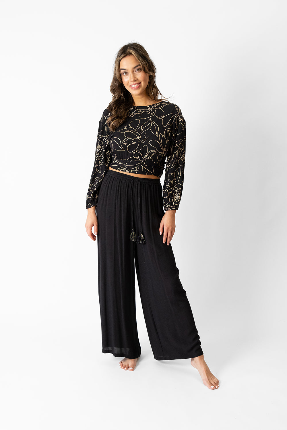 koy resort miami shine golden flower print long sleeve wrap top for spring 2024 women's fashion collection worn with miami wide leg pants