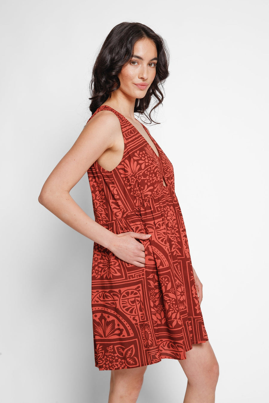 Woman wearing a red patterned dress on a white background