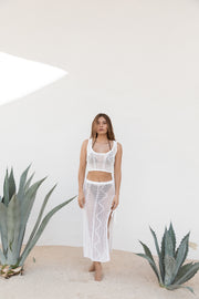 Blonde model facing front, wearing Cream Santorini Knit Crop Tank Top with rolled edges, scoop neck, and semi-sheer crochet fabric. Koy Resort affordable vacation, cruise, and resort-wear.