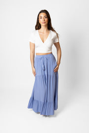 Brunette model facing front, wearing Bahama Blue Miami Tiered Boho Maxi Skirt with a flowy fit, adjustable elastic waistband and beaded drawcord, pockets, and white lining. Made from crinkle rayon. Perfect for bohemian beach days and romantic getaways. Koy Resort affordable vacation, cruise, and resort-wear.