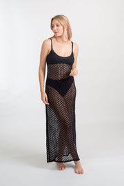 a blonde woman model wearing a black bikini set with a lightweight, zigzap patterend crochet, beach cover up midi slip dress from Koy Resort Zuma collection