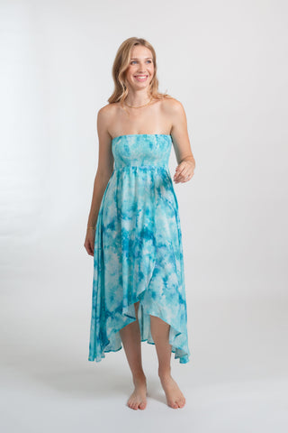 A woman wearing blue tie-dye convertible bandeau dress from Koy Resorts Aquarelle collection