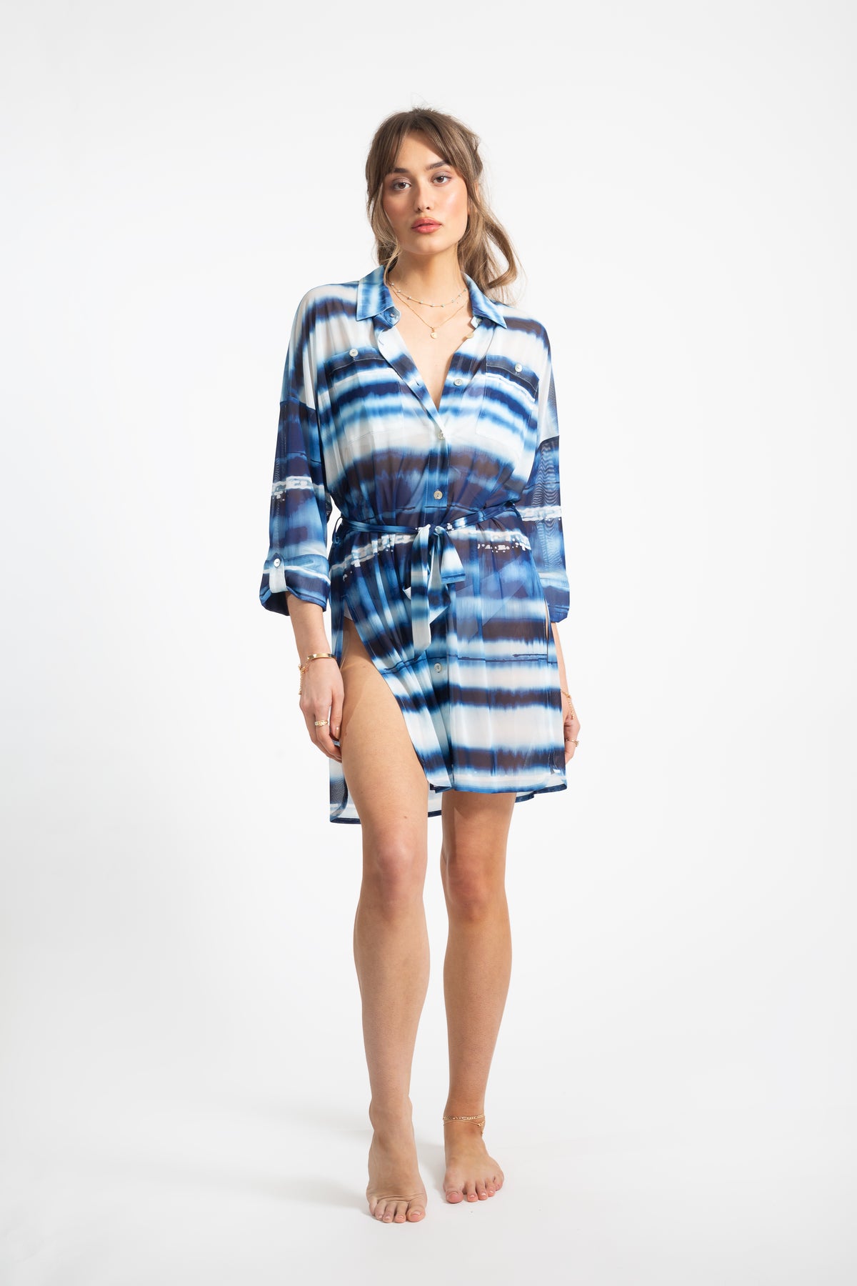 Brunette model wearing Mesh cover up short dress in seascape blue white patterned colour facing front. Koy Resort vacation cruise wear. 