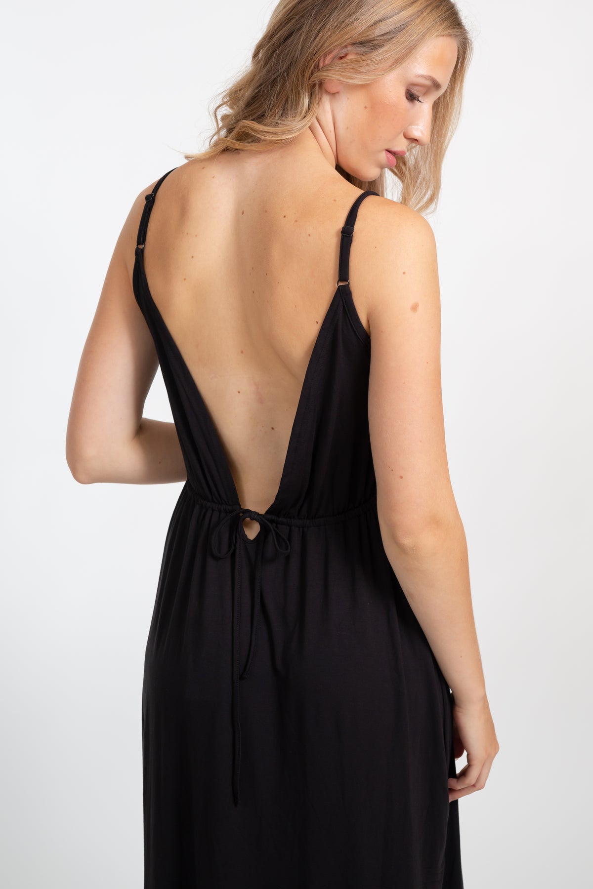 Blonde model wearing Black Brown Laguna Cotton deep-v neck strappy midi dress with side slit facing  back. Koy Resort affordable vacation, cruise and resort-wear.