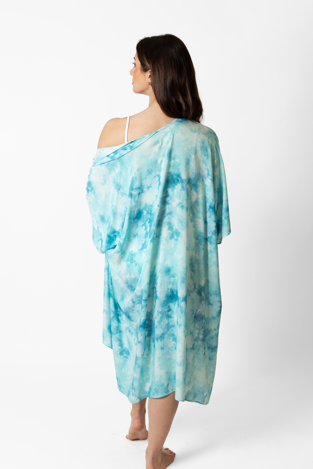 the back of a woman wearing a blue tie sye print kimono that goes up to her ankle with one side drop off her shoulder